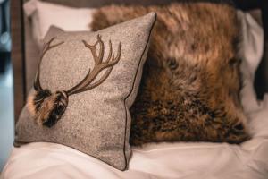 a pillow with a deer head on it on a bed at CASA LUMIRA Luxury apartment ski-in ski-out in Breuil-Cervinia