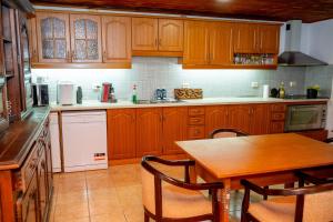 a kitchen with wooden cabinets and a wooden table at Стаи за гости - Аербул и приятели in Gabrovtsi