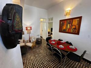 a living room with a table and chairs in a room at Cosy spacious apartments medina center in Essaouira