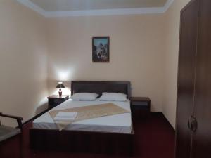 a bedroom with a large bed with white sheets at Гостевой дом Barakat in Samarkand