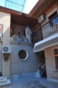 a brick building with a balcony and a staircase at Гостевой дом Barakat in Samarkand