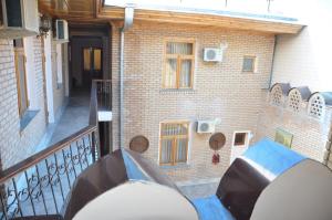 a balcony of a brick building with a blue table at Гостевой дом Barakat in Samarkand +4 photos