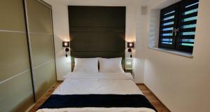 a bedroom with a bed with a large headboard at Tarnów Velo Apartament - Dom in Tarnów