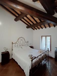 a bedroom with a white bed in a room with wooden ceilings at La casa dei breton in Magione