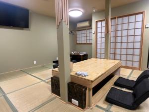 大阪Wafu Ryokan Uehonmachi的有桌椅和电视的房间