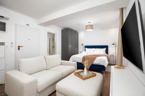 een witte woonkamer met een bed en een bank bij Travel Station in Pula