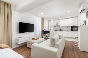 een witte woonkamer met een bank en een tv bij Travel Station in Pula