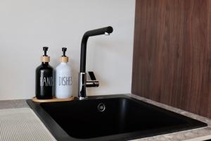 a black sink with two bottles and a faucet at Ghent Penthouse in Ghent