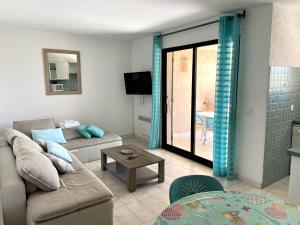 un soggiorno con un divano e un tavolo di Mini-villa Bocca del Oro - Sud Porto-Vecchio a Bocca del Oro