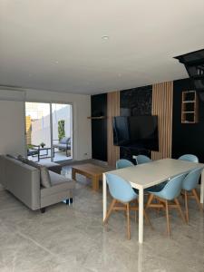 a living room with a table and a couch at Superbe villa familiale jardin in Montpellier