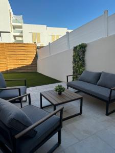a patio with two couches and a coffee table at Superbe villa familiale jardin in Montpellier