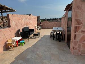 un patio avec des chaises et des tables sur un mur de briques dans l'établissement Suite La Vigna, à Catane