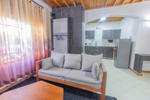 a living room with a couch and a kitchen at Almasi in Ukunda
