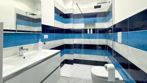 a bathroom with blue and white tiled walls and a toilet at B&B Agorà Nocera Centro in Nocera Inferiore