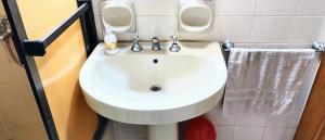 a white sink in a bathroom with two urinals at Habitación silenciosa Nº1 en Dpto Compartido in Cordoba