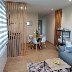 Una sala de estar con una mesa y un sofá azul. en Casa Da Ponte, en Lobios