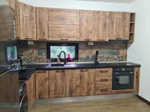a kitchen with wooden cabinets and a sink at Poiana Cerbilor in Slatina