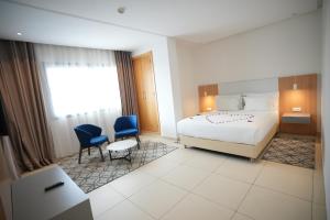 a hotel room with a bed and two chairs at Zephyr Agadir in Agadir