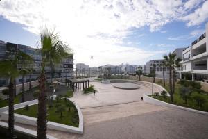 a courtyard in a city with palm trees and buildings at Zephyr Agadir in Agadir