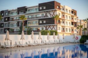 a hotel with chairs and umbrellas next to a swimming pool at Zephyr Agadir in Agadir