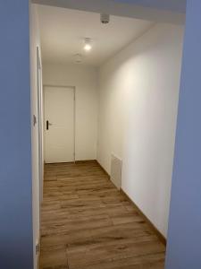 an empty hallway with a door and a wooden floor at Pretty Apartment Centrum in Suwałki