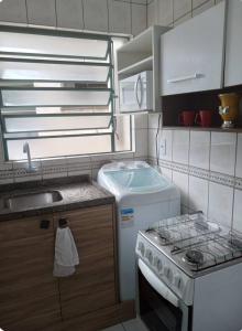 a small kitchen with a stove and a sink at Aluguel de apartamento in São Leopoldo +7 photos