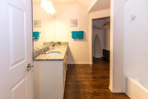 a bathroom with a sink and a mirror and a tub at Elegant, Spacious 3bedroom Near Attractions Hot Tub Pool & Gym in Kissimmee +13 photos