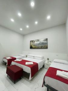 ナポリにあるMerlino Rooms Napoliの白い部屋のベッド2台 赤いシーツ付