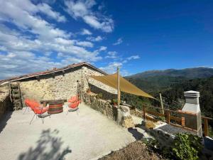 ein Haus mit einer Terrasse mit Stühlen und einem Zelt in der Unterkunft CASA ViLLAR in Colunga