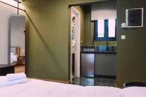 a bedroom with a bed and a kitchen in a room at Four Stay Apartments Olive Room in Volos