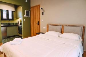 a bedroom with a large bed with two towels on it at Four Stay Apartments Olive Room in Volos