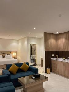 a living room with a blue couch and a bed at ليبرا سويتس - Libra Suites in Khamis Mushayt