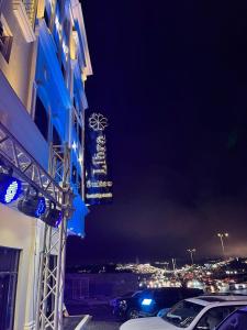 a lit up sign on the side of a building at night at ليبرا سويتس - Libra Suites in Khamis Mushayt
