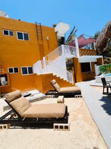 ChuburnáにあるDepartamento a 200 mts de la playaの家の前に2つの長椅子がある