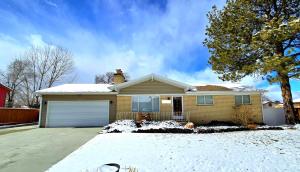 a yellow house with a snow covered driveway at Booking - Hoskere Homes in Sandy