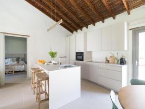une cuisine avec des placards blancs et un îlot de cuisine dans l'établissement Casa rural cercado de don paco, à Santa Lucía