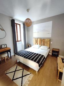 a bedroom with a large bed and a desk at Maison 13 pers à 10mn de Luchon in Cazaux-Layrisse
