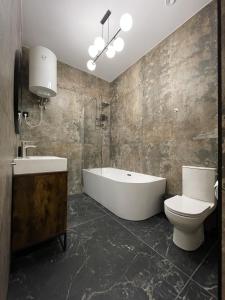 a bathroom with a tub and a toilet and a sink at Aleja 12 in Częstochowa