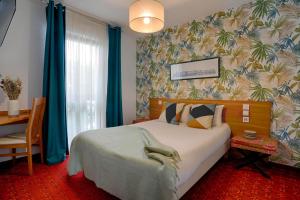 a bedroom with a large bed with blue drapes at Hotel Le Branhoc - Brit Hotel Auray in Auray