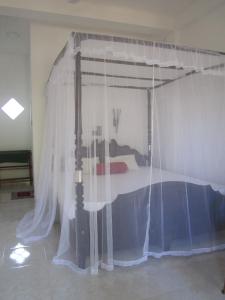 a bed with a canopy in a room at Serene Niche in Mirissa