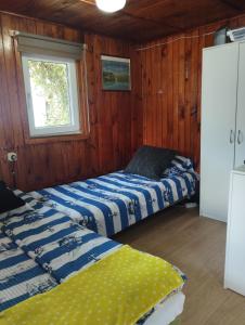 two beds in a room with a window at Domki 13-nastka in Międzyzdroje