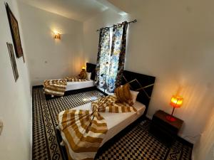 a hotel room with two beds and a window at Cosy spacious apartments medina center in Essaouira