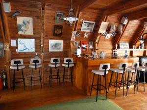 a bar in a log cabin with stools at Heidi Haus in Port Alfred
