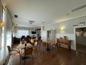 a living room with tables and chairs and a couch at Albergue Jakue in Puente la Reina