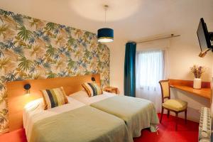 a hotel room with two beds and a desk at Hotel Le Branhoc - Brit Hotel Auray in Auray +204 photos