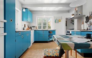 a kitchen with blue cabinets and a table at Gorgeous Home In Skagen With Wifi in Skagen
