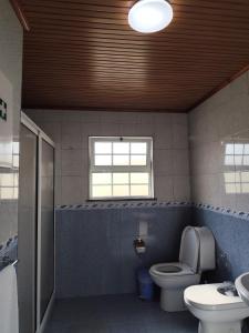 a bathroom with a toilet and a sink and a window at Vista de Sonho in Calheta +6 photos