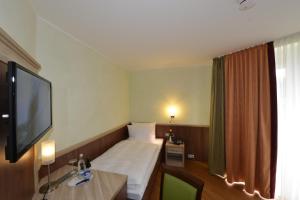 a hotel room with a bed and a flat screen tv at Rheinhotel Larus in Kaltenengers