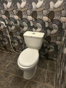 a white toilet in a bathroom with a log wall at Eleven Thalalla in Talalla South