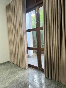 an empty room with curtains and a glass door at Eleven Thalalla in Talalla South +8 photos